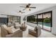 Bright living room with sliding glass doors and views of the lush backyard and sparkling pool at 7032 Pelican Island Dr, Tampa, FL 33634