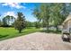 Beautifully designed brick paver patio overlooking a lush, expansive backyard with mature trees at 7103 Bridgeview Dr, Wesley Chapel, FL 33545