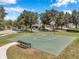 Outdoor basketball court with a bench surrounded by mature trees in a community park at 7103 Bridgeview Dr, Wesley Chapel, FL 33545