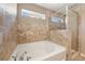 Luxurious bathroom features a soaking tub, a separate glass-enclosed shower, and stylish tile work at 7103 Bridgeview Dr, Wesley Chapel, FL 33545