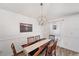 Charming dining area featuring modern light fixture, wood table, and wainscoting at 7103 Bridgeview Dr, Wesley Chapel, FL 33545