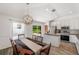 Light-filled dining area near the kitchen, featuring backyard views and modern chandelier at 7103 Bridgeview Dr, Wesley Chapel, FL 33545