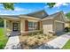 Charming home with stone accents, well-maintained landscaping, and a covered porch providing inviting curb appeal at 7103 Bridgeview Dr, Wesley Chapel, FL 33545