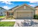 Well-maintained single-story home featuring an attached two-car garage, manicured landscaping, and a welcoming facade at 7103 Bridgeview Dr, Wesley Chapel, FL 33545
