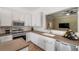 Updated kitchen featuring stainless steel appliances, modern backsplash, and open view to the living area at 7103 Bridgeview Dr, Wesley Chapel, FL 33545