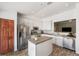Modern kitchen featuring stainless steel appliances, granite countertops, a central island, and sleek white cabinetry at 7103 Bridgeview Dr, Wesley Chapel, FL 33545