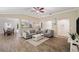 Open-concept living room featuring wood floors, recessed lighting, comfortable seating, and seamless flow into the dining area at 7103 Bridgeview Dr, Wesley Chapel, FL 33545
