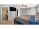 Comfortable primary bedroom suite includes a TV, ceiling fan and adjoins the ensuite bathroom and walk-in closet at 7103 Bridgeview Dr, Wesley Chapel, FL 33545