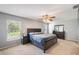Spacious main bedroom with a ceiling fan, plush carpeting, and an abundance of natural light from the large window at 7103 Bridgeview Dr, Wesley Chapel, FL 33545