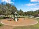 Outdoor playground with slides and swings surrounded by mature trees and a mulch ground cover at 7103 Bridgeview Dr, Wesley Chapel, FL 33545