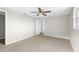 Bright bedroom featuring neutral carpeting, a ceiling fan and closet with a partially open door at 7215 San Moritz Dr, Port Richey, FL 34668