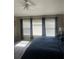 Bedroom featuring a large bed, three windows with curtains, and wood floors at 7838 66Th N Way, Pinellas Park, FL 33781