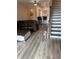 Open-concept living area with hardwood floors, a large leather couch, and views to the kitchen and stairs at 7838 66Th N Way, Pinellas Park, FL 33781