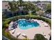 Aerial view of community pool with plenty of lounge chairs and lush tropical palm trees at 7838 66Th N Way, Pinellas Park, FL 33781