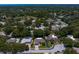 Beautiful aerial view of a home nestled in a lush neighborhood with mature trees and a glimpse of the ocean in the distance at 80 Sycamore Ct, Palm Harbor, FL 34683
