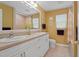 Well-lit bathroom with double sinks, a wide mirror, and classic white cabinetry at 80 Sycamore Ct, Palm Harbor, FL 34683