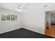 A bright bedroom showcases a large window, plush carpet, ceiling fan, and neutral paint at 80 Sycamore Ct, Palm Harbor, FL 34683