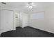 A clean and minimalist bedroom provides ample closet space, a window, a ceiling fan, and neutral walls at 80 Sycamore Ct, Palm Harbor, FL 34683