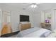 Bedroom features a mounted TV, ceiling fan, light walls, and a desk space with natural light at 80 Sycamore Ct, Palm Harbor, FL 34683