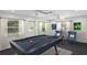 Spacious game room with a pool table, seating, large windows, and decorative billiards art at 80 Sycamore Ct, Palm Harbor, FL 34683