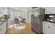 Modern kitchen with stainless steel appliances, white cabinetry, and a cozy dining area with a view at 80 Sycamore Ct, Palm Harbor, FL 34683
