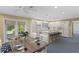 Bright open-concept kitchen featuring white cabinets, granite countertops, and a dining area with backyard access at 80 Sycamore Ct, Palm Harbor, FL 34683