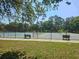 Fenced in tennis courts with benches in Westlake Village at 80 Sycamore Ct, Palm Harbor, FL 34683