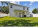 Expansive backyard featuring lush green grass, a covered patio area, and a pristine white fence at 807 W Kentucky Ave, Tampa, FL 33603