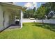 Covered patio area overlooking a spacious backyard with a well-maintained lawn and a white fence at 807 W Kentucky Ave, Tampa, FL 33603