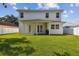 Large backyard with a covered patio, green grass, and a white privacy fence at 807 W Kentucky Ave, Tampa, FL 33603