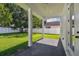 Covered patio with gray brick pavers offering a view of the grassy backyard and white fence at 807 W Kentucky Ave, Tampa, FL 33603