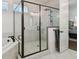 Bathroom featuring a glass shower, soaking tub, black fixtures, and a view into the main bedroom at 807 W Kentucky Ave, Tampa, FL 33603