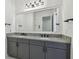 Bathroom vanity with double sinks, granite countertops, a large mirror, and black hardware at 807 W Kentucky Ave, Tampa, FL 33603
