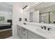 Bright bathroom with double sinks, gray cabinets, quartz countertop, and a view into the main bedroom at 807 W Kentucky Ave, Tampa, FL 33603