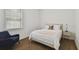 Cozy bedroom featuring a queen bed with white linens, a blue chair, and hardwood floors at 807 W Kentucky Ave, Tampa, FL 33603