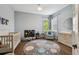 Bedroom with hardwood floors, large windows, a crib, and a comfortable seating area at 807 W Kentucky Ave, Tampa, FL 33603