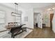 Light filled dining room features a dark wood table with a bench, a geometric light fixture, and hardwood floors at 807 W Kentucky Ave, Tampa, FL 33603