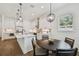 Modern kitchen with white cabinetry, stainless steel appliances, a center island, and a dining area at 807 W Kentucky Ave, Tampa, FL 33603