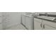 Laundry area with white washer and dryer set, utility sink, granite countertop, and convenient storage at 807 W Kentucky Ave, Tampa, FL 33603