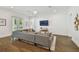 Bright living room with a plush sectional couch, white walls, and wood floors at 807 W Kentucky Ave, Tampa, FL 33603