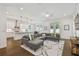 Bright open living space with hardwood floors, a large gray sectional sofa, and a view into the kitchen at 807 W Kentucky Ave, Tampa, FL 33603