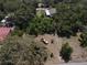 An aerial view of a vacant lot is surrounded by trees and homes at 8601 N 28Th St, Tampa, FL 33604