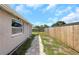 Fenced backyard with a stone paver pathway along side of the home at 8805 Plum Grove Ct, Tampa, FL 33634
