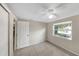 This bedroom features tile floors, a ceiling fan, and a view to the backyard through the window at 8805 Plum Grove Ct, Tampa, FL 33634