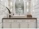 Bathroom vanity featuring white vessel sink, dark countertop and decorative sconces at 100 Oakmont Ln # 310, Belleair, FL 33756