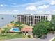 Multi-story condo building with pool, palm trees, waterfront view and well-manicured lawn at 100 Oakmont Ln # 310, Belleair, FL 33756