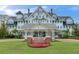Elegant Belleview Inn featuring a grand entrance, manicured lawn, and beautiful landscaping at 100 Oakmont Ln # 310, Belleair, FL 33756