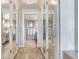 Hallway with white wood floors and doors leading to bathrooms and closets at 100 Oakmont Ln # 310, Belleair, FL 33756