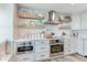 Modern kitchen featuring custom cabinetry, stainless steel appliances, and stylish open shelving at 100 Oakmont Ln # 310, Belleair, FL 33756