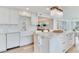 Bright kitchen features an island with seating, granite countertops, farmhouse sink and decorative backsplash at 100 Oakmont Ln # 310, Belleair, FL 33756